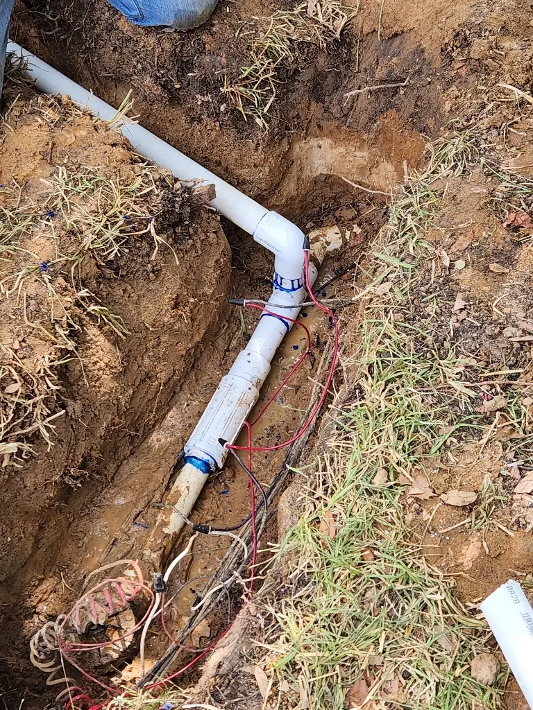 Trench with new PVC irrigation pipe during a sprinkler system installation